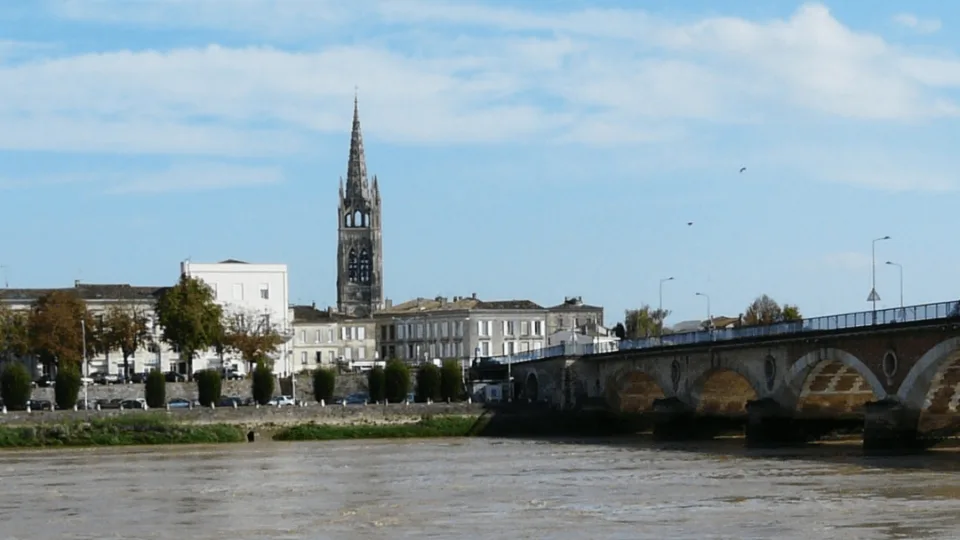 Pont de pierre et clocher de l'église Saint-Jean-Baptiste à Libourne, vue depuis les rives de la Dordogne lors d'une escapade en train depuis Bordeaux.