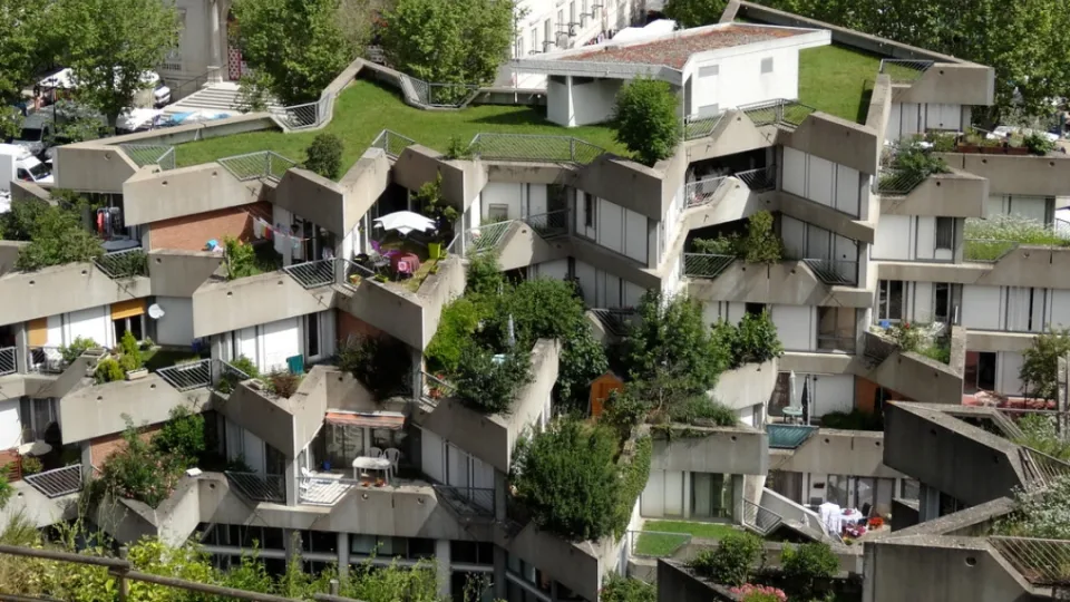 Vue de la Cité des Étoiles à Givors, immeuble brutaliste aux terrasses végétalisées, accessible en 16 min de train depuis Lyon pour une escapade architecturale.