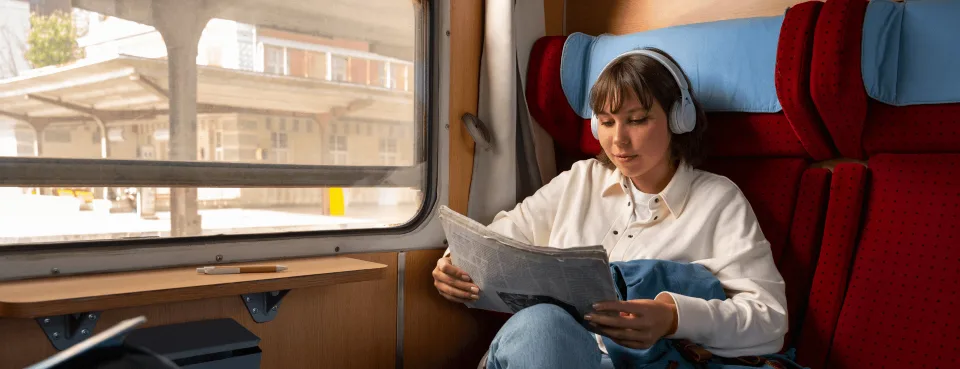 Voyageuse détendue lisant dans un train - l'atmosphère calme et authentique des escapades SlowBreak
