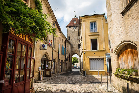 Rue pavée et porte médiévale de la cité fortifiée de Saint-Macaire, près de Bordeaux, idéale pour une escapade en train à moins d'1h.